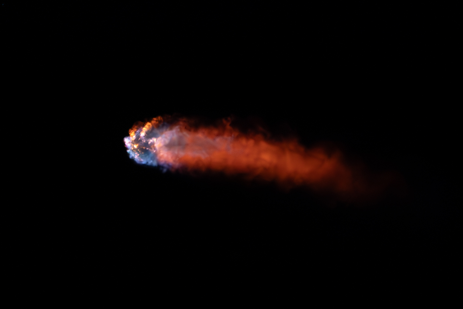 SpaceX Crew-2 engine plume glowing against the night sky